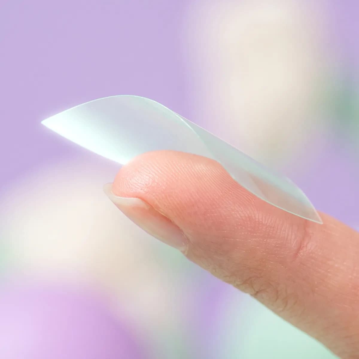 An almost-invisible beam strip draped over a fingertip.